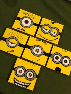 six minion faces painted on yellow cardboards with eyes and nose drawn on them