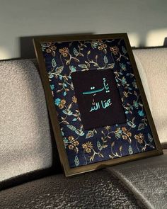 an arabic calligraphy is displayed on the back of a couch