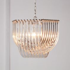 a glass chandelier hanging from a ceiling in a room with white walls and flooring