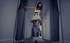 a woman standing in front of a curtain with musical notes on her body and legs