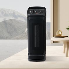 an air purifier sitting on top of a table next to a window