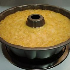 a cake pan filled with yellow batter on top of a stove burner, ready to be baked