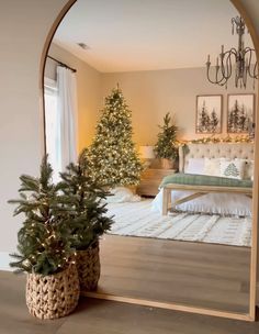 a mirror reflecting a bedroom with a christmas tree in the foreground and a bed in the background