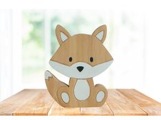 a wooden cutout of a fox sitting on top of a wooden table next to a window