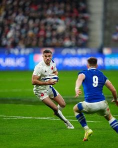 a rugby player running with the ball in his hand and another player on the other side