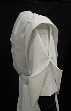 an unbuttoned white shirt is displayed on a mannequin's head