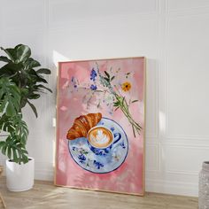 a coffee cup and croissant on a saucer with flowers in the background