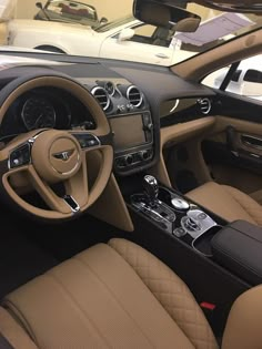 the interior of a car with tan leather and black trims, including steering wheel