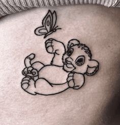 a small tattoo on the back of a woman's stomach depicting a baby bear holding a butterfly