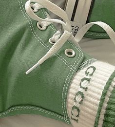 a pair of green tennis shoes with white laces