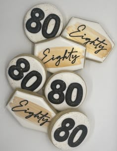 several decorated cookies with black numbers and writing on them are arranged in the shape of an 80