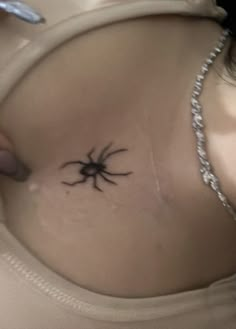 a woman with a spider tattoo on her stomach