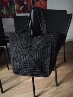 a black purse sitting on top of a chair