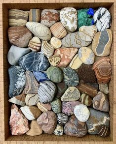 a wooden box filled with lots of different types of rocks and stones on top of each other