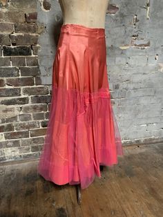 This is an absolutely gorgeous luscious piece. !950s silk petticoat/half slip. Very glamorous. The base is made from pink silk - probably habutae. Metal zipper. Two metal hooks and eyes at waist. The waist sits high. There is a 2" wide piece of elastic at the waist.  It is very slightly stretched. Still functioning but could perhaps be replaced. I don't personally think its serving any purpose. There is an outer layer of fine tulle starting quite low down over the silk.  It is kind of hitched up Pink Satin Evening Bottoms, Pink Silk Evening Skirt, Pink Satin Flared Skirt, Fitted Pink Tulle Bottoms, Pink Satin Long Skirt, Pink Satin Party Skirt, Pink Satin Skirt For Party, Silk Wedding Skirt For Summer, Silk Wedding Bottoms For Summer