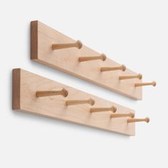 two wooden pegs are attached to the wall and hang on it's sides