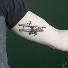 a small airplane tattoo on the arm