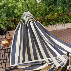 a large black and white striped hammock sitting on top of a wooden deck