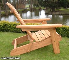 a wooden lawn chair sitting in the grass