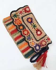 a crocheted purse with tassels on it