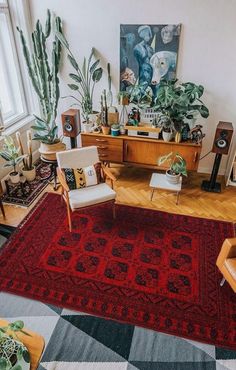 a living room filled with lots of furniture and plants on top of a red rug