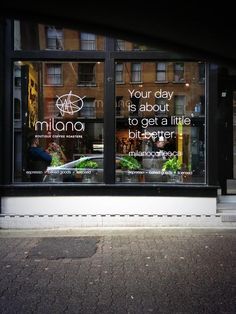 a store front window with the reflection of buildings in it's glass windows and an advertisement that reads, your day is about to get a little bitterer