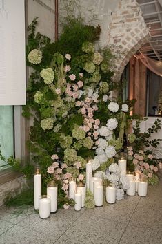 flowers and candles are lined up on the floor