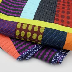 several different colored pieces of fabric stacked on top of each other with dots and circles