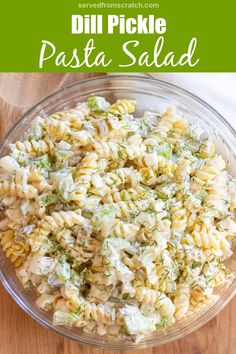 pasta salad in a glass bowl on top of a wooden table with the words dill pickle pasta salad