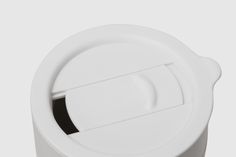 a close up of a white cup with a lid