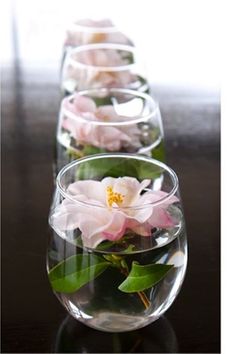 two vases filled with flowers on top of a wooden table next to each other