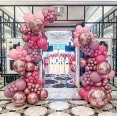 an entrance decorated with pink and gold balloons