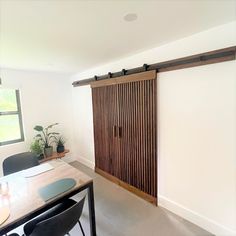 a room with a table, chair and sliding door that is made out of wood