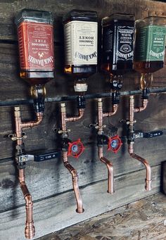 several different types of beer are hanging on the wall next to pipes and faucets