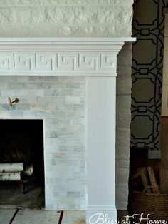 a white fireplace with black and white wallpaper