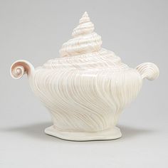 a white ceramic tea pot sitting on top of a table