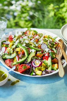 a salad with avocado, tomatoes and other vegetables