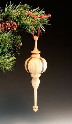 a wooden ornament hanging from a pine tree