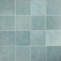 a tile floor with different shades of blue and grey tiles on it, including one red square