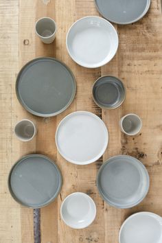 a wooden table topped with plates and bowls