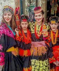 four girls in colorful costumes posing for the camera