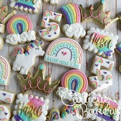 decorated cookies with rainbows, clouds, and unicorns on top of a wooden table