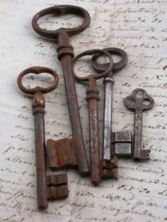 an assortment of old rusty keys laying on top of a table