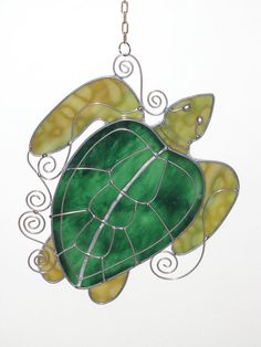 a stained glass turtle ornament hanging from a chain