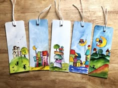 four bookmarks with houses painted on them hanging from clothes pins, each one has a different color scheme