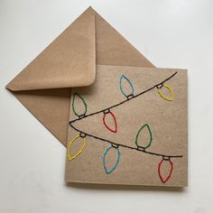 an envelope with a string of lights on it next to a piece of brown paper