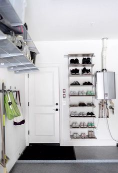 a white closet filled with lots of shoes next to a wall mounted air conditioner