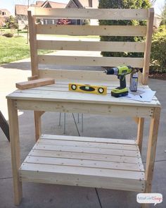 a work bench made out of pallet wood with a drill and glue bottle on top