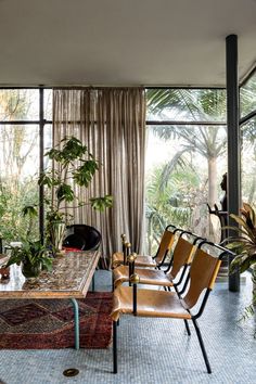 a living room filled with lots of furniture and plants