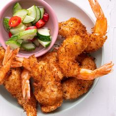 shrimp with cucumber and tomato salad served in bowl on white tablecloth, top view